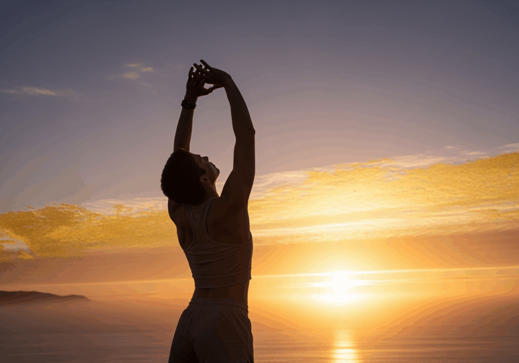A vibrant person stretching outdoors with arms raised toward the sky, surrounded by natural sunlight, representing physical vitality and energy